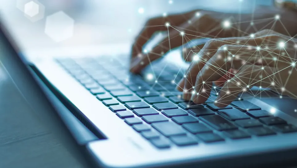 Mãos digitando em notebook com elementos gráficos de conexão sobrepostos
